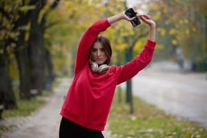 Athletic young woman taking a breath and relaxing after jogging and stretching. Woman Training and Workout Exercises On Street. photo
