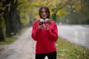 Athletic young woman taking a breath and relaxing after jogging and stretching. Woman Training and Workout Exercises On Street. photo