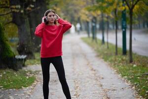 Athletic young woman taking a breath and relaxing after jogging and stretching. Woman Training and Workout Exercises On Street. photo