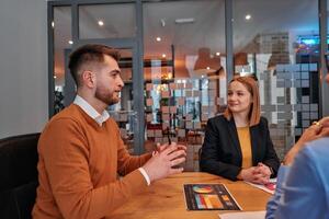 In the vibrant ambiance of a modern startup office, a diverse team of business professionals engage in discussions on various projects and develop new business strategies, epitomizing creativity and photo