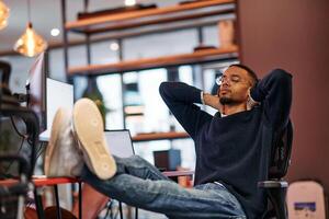 Exhausted African American Programmer Resting at Work. photo
