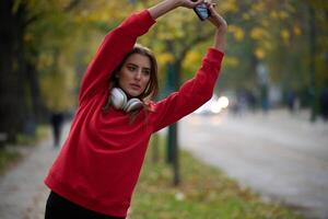 Athletic young woman taking a breath and relaxing after jogging and stretching. Woman Training and Workout Exercises On Street. photo