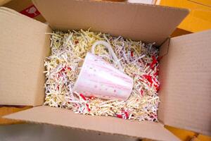 Goods delivery concept. A lining drinking glasses with recycled paper to protect them from shock in a cardboard box. photo