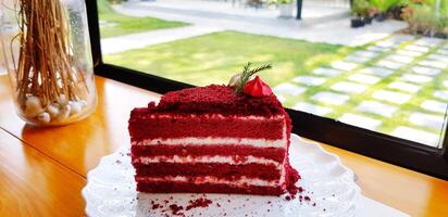 Piece of Raspberry red velvet cake with Lemon cream cheese frosting on white plate with copy space and window background. Sweet dessert, Delicious and Caf time concept. photo