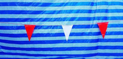 Small red and white flag hanging or isolate on line pattern of blue plastic background or wall. Target and Goal of life concept photo