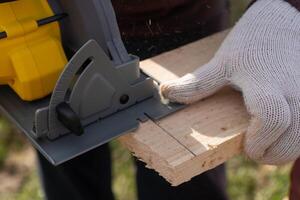 Man sawing board with a circular saw. High quality photo