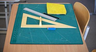 Classroom desk with math tools, ruler, and eraser on a cutting mat photo