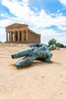 Agrigento, Italy-May 10, 2022-The Temple of Concordia and fallen Icarus inside the valley of the temples, an archaeological park near Agrigento during a sunny day photo