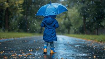 Child with blue umbrella walking in the rain photo