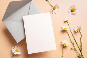 Empty blank card, envelope and chamomile flowers photo