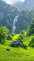 Landscape featuring cows grazing on a lush green meadow with several rustic wooden cabins and a waterfall in the background. photo
