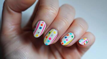 Bright and Playful Nail Art Design Featuring Polka Dots and Stripes for a Fun and Stylish Look photo