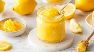 Fresh Lemon Curd in Glass Jar with Sliced Lemons and Honey Dipper on Marble Countertop for Culinary Use and Dessert Preparation photo