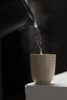 A serene scene with steam rising from a cup on a stark background. photo