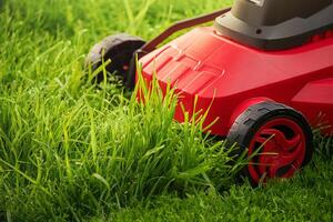 A red and black lawnmower on a background of green grass. photo