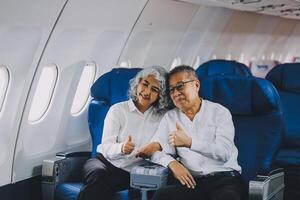 A mature couple enjoys a plane ride sitting near the window. They looked out into the sky. Immerse yourself in the scenery and excitement of the journey. To create precious memories together photo