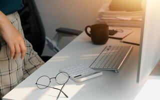 Desk with laptop, eye glasses, earphone, pen and a cup of coffee. Top view with copy space. photo
