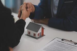 Estate agent shaking hands with customer after contract signature photo