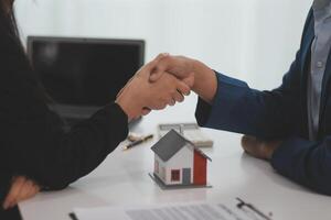 Estate agent shaking hands with customer after contract signature photo