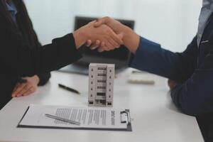 Estate agent shaking hands with customer after contract signature photo