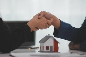 Estate agent shaking hands with customer after contract signature photo