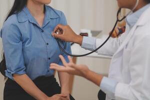 Asian doctor is using a stethoscope listen to the heartbeat of the elderly patient. photo
