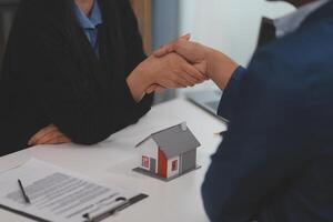 Estate agent shaking hands with customer after contract signature photo
