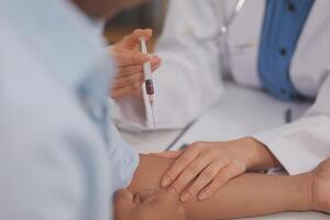 Doctor uses hypodermic needle and syringe to put a dose of medicine as treatment. photo