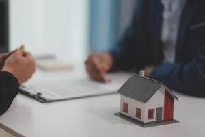 Estate agent giving house keys to client after signing agreement contract real estate with approved mortgage application form, concerning mortgage loan offer for and house insurance. photo