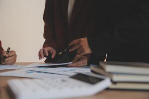 Group of confident business people point to graphs and charts to analyze market data, balance sheet, account, net profit to plan new sales strategies to increase production capacity. photo