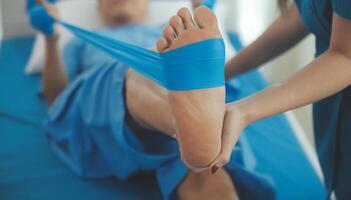 Physical therapists work with patients in close-up clinics. The concept of rehabilitation of physical health, the doctor gives advice to the patient. Ankle problems and muscle injuries photo