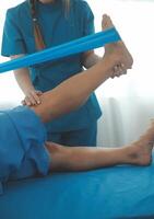 Physical therapists work with patients in close-up clinics. The concept of rehabilitation of physical health, the doctor gives advice to the patient. Ankle problems and muscle injuries photo