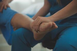 Physical therapists work with patients in close-up clinics. The concept of rehabilitation of physical health, the doctor gives advice to the patient. Ankle problems and muscle injuries photo