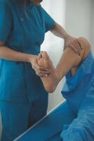Physical therapists work with patients in close-up clinics. The concept of rehabilitation of physical health, the doctor gives advice to the patient. Ankle problems and muscle injuries photo