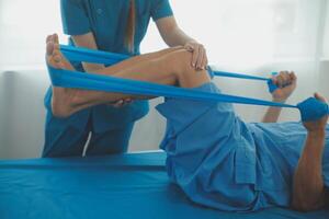 Physical therapists work with patients in close-up clinics. The concept of rehabilitation of physical health, the doctor gives advice to the patient. Ankle problems and muscle injuries photo