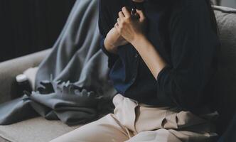 A woman with a cold with pills is treated at home chooses which drugs to take and self-medicates, checks the expiration date while sitting on the couch at home photo