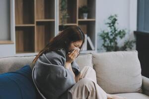 A woman with a cold with pills is treated at home chooses which drugs to take and self-medicates, checks the expiration date while sitting on the couch at home photo
