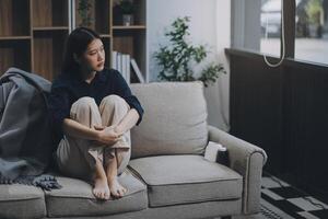 A woman with a cold with pills is treated at home chooses which drugs to take and self-medicates, checks the expiration date while sitting on the couch at home photo