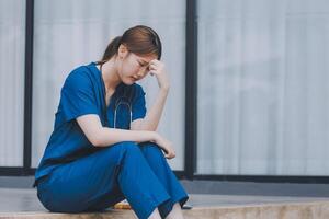 Stressed doctor sitting in front of office, working pressure. photo
