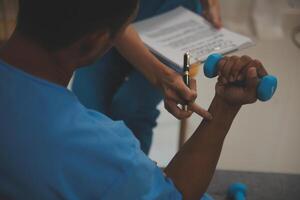 Professional physical therapist examines and cares for a young man in a physical therapy center, treating muscles and injuries of a man in a hospital. photo