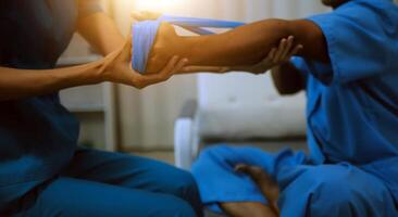 Professional physical therapist examines and cares for a young man in a physical therapy center, treating muscles and injuries of a man in a hospital. photo