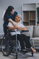 Asian physiotherapist helping elderly woman patient stretching arm during exercise correct with dumbbell in hand during training hand with patient Back problems in garden. Nursing home hospital photo