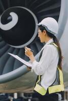 Technician fixing the engine of the airplane,Female aerospace engineering checking aircraft engines,Asian mechanic maintenance inspects plane engine photo
