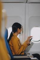 Texting on mobile chat app, Thoughtful asian people female person onboard, airplane window, perfectly capture the anticipation and excitement of holiday travel. chinese, japanese people. photo