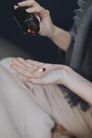 A woman with a cold with pills is treated at home chooses which drugs to take and self-medicates, checks the expiration date while sitting on the couch at home photo