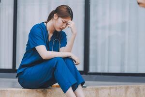 Stressed doctor sitting in front of office, working pressure. photo