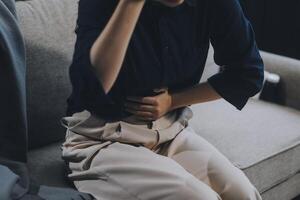 A woman with a cold with pills is treated at home chooses which drugs to take and self-medicates, checks the expiration date while sitting on the couch at home photo