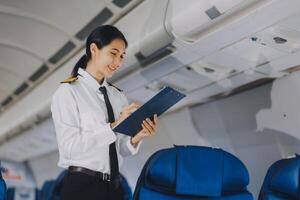 Asian woman working and planning on an airplane. Asian woman reading a book while sitting on an airplane. photo