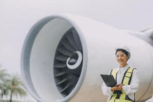 Technician fixing the engine of the airplane,Female aerospace engineering checking aircraft engines,Asian mechanic maintenance inspects plane engine photo