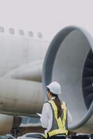 Technician fixing the engine of the airplane,Female aerospace engineering checking aircraft engines,Asian mechanic maintenance inspects plane engine photo